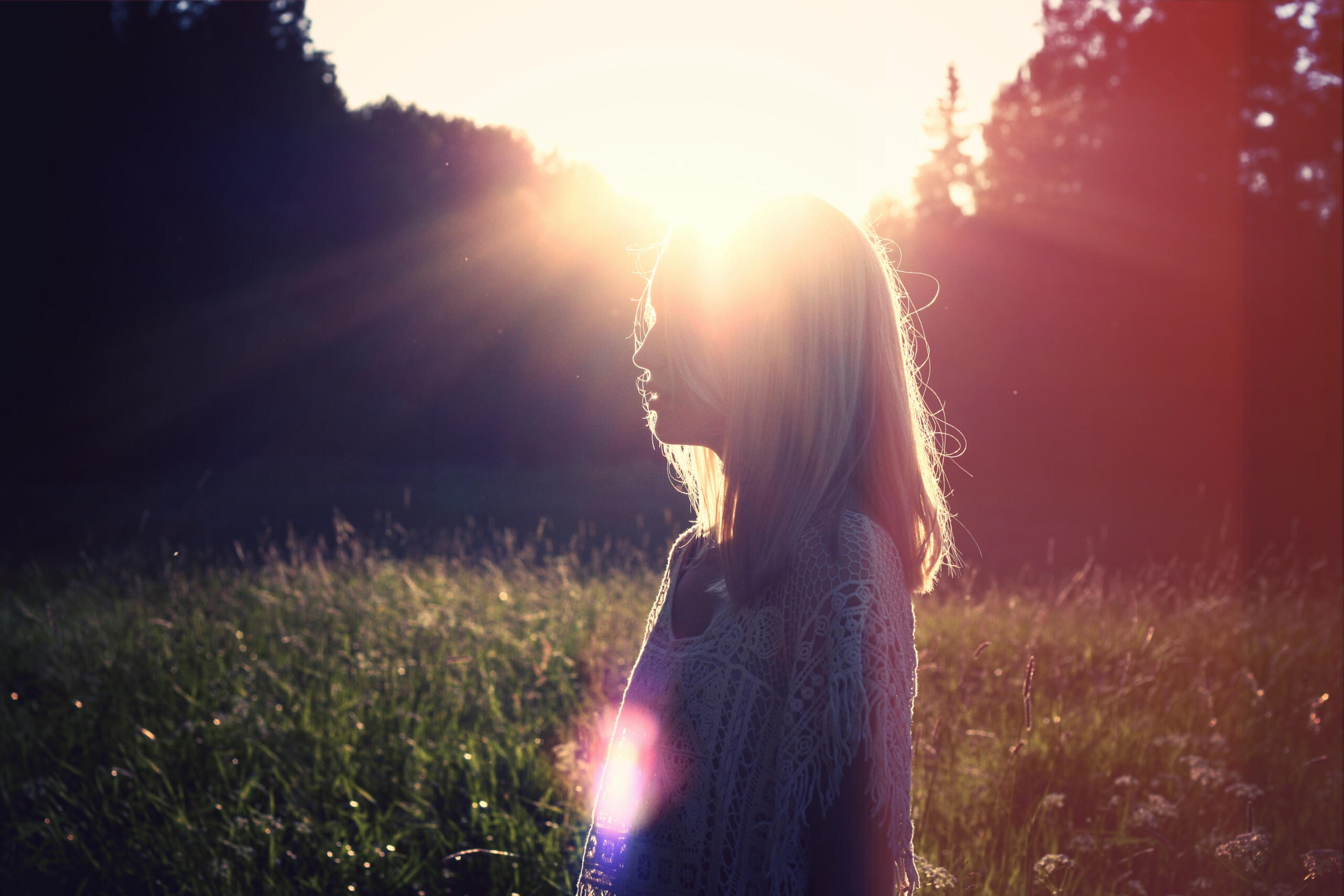 Feminine woman standing in dappled sunlight