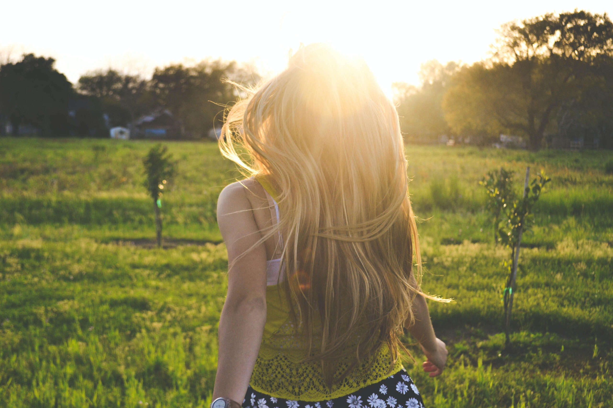 Woman with long hair running into the sun